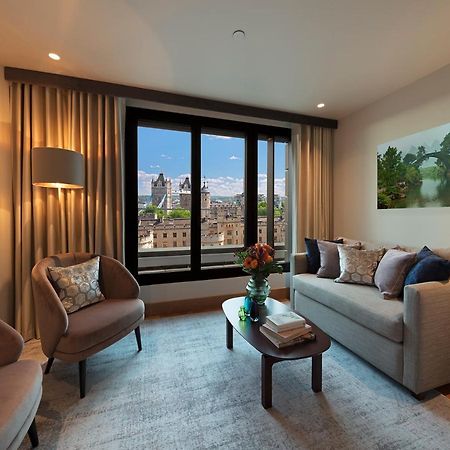 Tower Suites By Blue Orchid Лондон Екстериор снимка The photo depicts a modern living room with a contemporary design. It features two stylish, circular chairs and a comfortable sofa adorned with various decorative pillows. A small coffee table is positioned in front of the sofa, topped with books and
