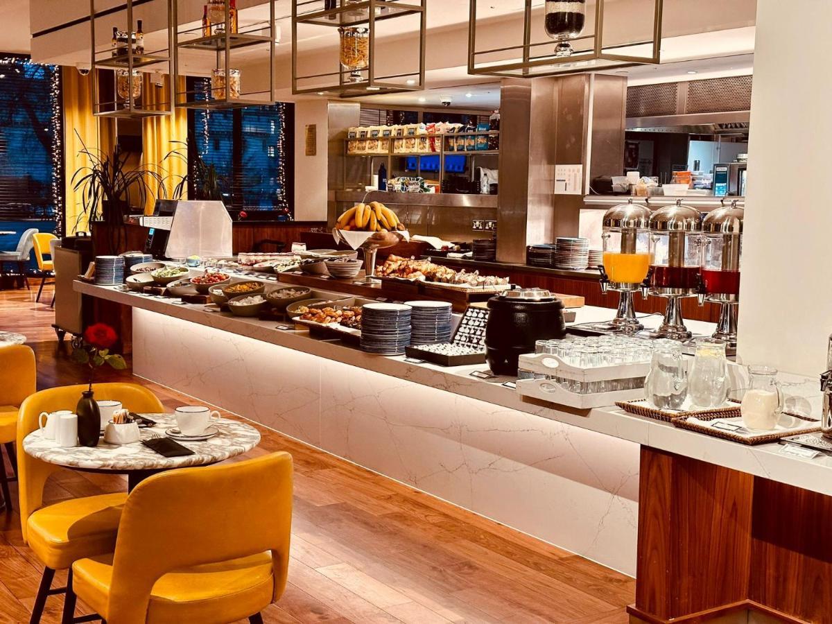 Tower Suites By Blue Orchid Лондон Екстериор снимка The photo depicts a modern buffet setting, featuring an array of food items displayed elegantly on a long countertop. There are various dishes, likely including pastries, fruits, and other breakfast items, arranged neatly. In the background, there ar